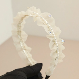 Dettaglio cerchietto in mesh crema a pieghe con perle e cristalli a cuore
