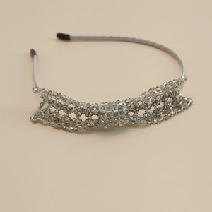 Detail of handcrafted grey crystal bead bow on an elegant silk wrapped headband