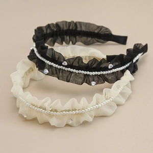 Dettaglio del cerchietto in tulle plissettato con strass a cuore e perle raffinate