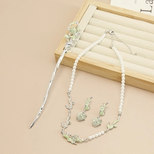 Macro detail of silver fluid metal necklace and hairpin set with green cat eye stones