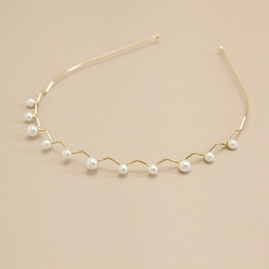 Elegante gouden metalen haarband met witte parels in een minimalistisch zigzagontwerp