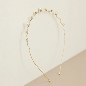 Detail van golvende gouden parelhoofdband met kleine witte parels en fonkelende strass