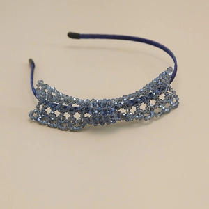 Close-up of handmade blue crystal beaded headband with intricate woven hollow lace details