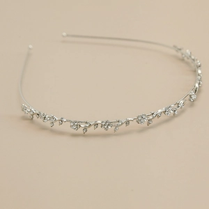 Detailed view of silver flower headband with sparkling rhinestones and leaf motifs
