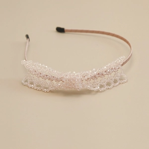 Detail of hand-woven light pink crystal beads and satin fabric on the elegant headband