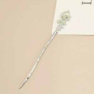 Macro detail of vintage silver hair pin with green opal bead and enamel floral patterns