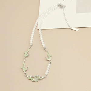 Detail of pearl necklace with irregular silver frame and green heart opal pendant