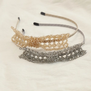 Detailed shot of handmade woven crystal bow headbands in champagne and smoke grey