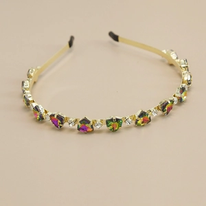 Détail d'un serre-tête doré avec cristaux géométriques arc-en-ciel et strass brillants