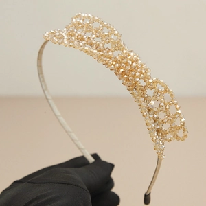 Handcrafted champagne gold crystal woven bow headband on a professional display background