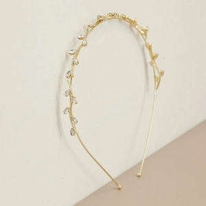 Detail of gold branch-shaped headband featuring marquise crystal leaves and metallic shine
