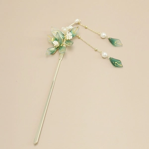 Detailed view of champagne gold hair pin with green petals and elegant metal tassels