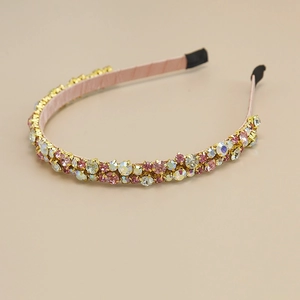 Close-up of pink gauze headband with double-row sparkling rhinestones and soft satin texture
