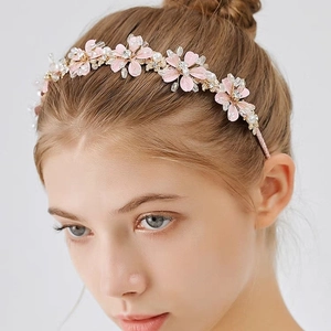 Détail d'un serre-tête à fleurs roses avec perles blanches et détails en cristaux brillants