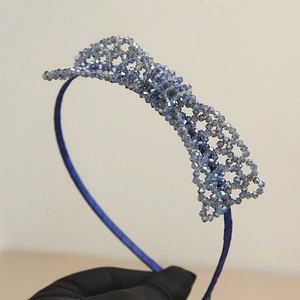 Detail of hand-woven dark blue crystal bead headband with metallic frame and satin wrap