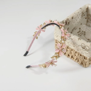 Détail du serre-tête fleurs roses avec perles, feuilles dorées et dents antidérapantes