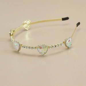 Détail d'un serre-tête doré fin avec cinq gemmes en forme de cœur et strass brillants