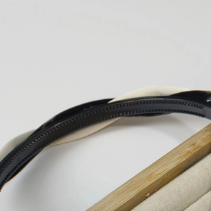 Detail view of the twisted black and white leather texture headband with anti-slip teeth