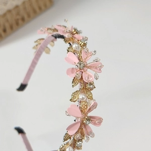 Détail du bandeau floral rose avec feuilles dorées, perles blanches et cristaux brillants