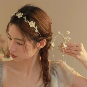 Detail of floral headband with yellow flowers, green leaves and white pearls for hair