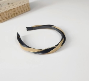Detail of twisted black and beige headband featuring sparkling white rhinestones