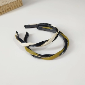 Detailed view of twisted two-tone leather headbands with rhinestones and non-slip teeth