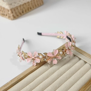 Serre-tête floral élégant avec fleurs roses, feuilles dorées et perles sur plateau