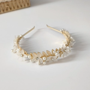 Détails du serre-tête doré avec fleurs blanches mates et perles de mariage