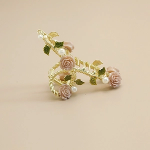 Detail view of golden vine hair claw with resin pink roses and white pearl accents