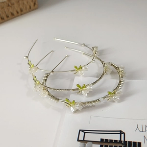 Detail of lily of the valley headband with white floral petals, pearls and crystals