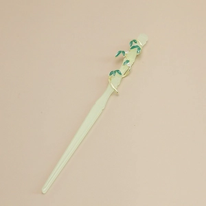 Detailed view of bamboo style hair pin with gold vines and green enamel leaf accents