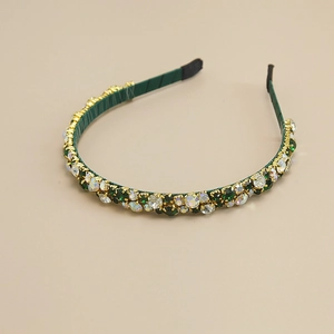 Detail view of green gauze headband with luxury crystals and gold prong settings