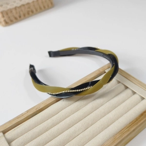 Close-up of twisted black and olive green headband with delicate rhinestone inlay