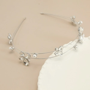 Detail of silver double-layered headband featuring sparkling rhinestones and white pearls