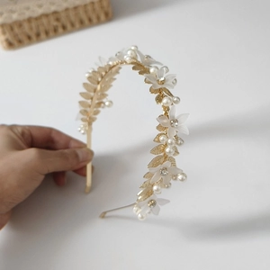 Détail du serre-tête feuilles dorées avec fleurs blanches mates, perles et strass