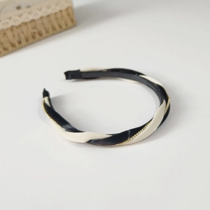 Close-up of black and beige twisted leather headband with sparkling rhinestone chain detail