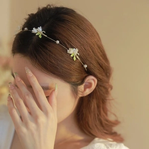 Detail view of dainty floral headband with white petals and pearls on thin wire