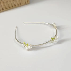Detail view of silver floral headband with white lily of the valley and sparkling crystals
