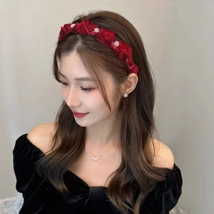Close-up of velvet pleated headband with burgundy flowers and pearl embellishments