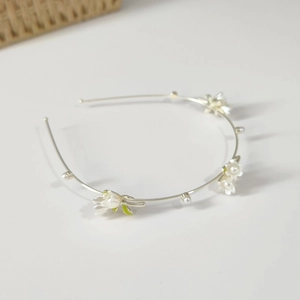 Detail of silver floral headband with white lily of the valley flowers and pearls