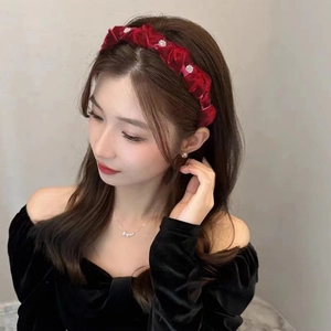 Elegant deep red velvet headband with pearl flower accents worn by a female model