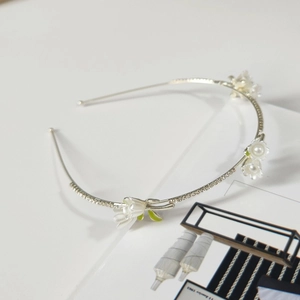 Detail of floral headband with white pearls and sparkling rhinestones on metal base
