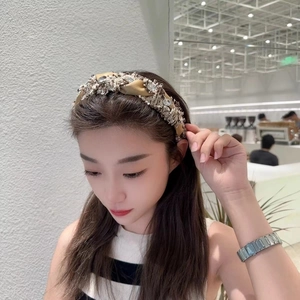 Détail du serre-tête en tweed tressé avec cristaux cousus main sur un modèle