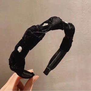 Detail view of black velvet twisted headband with sparkling rhinestones and elegant texture