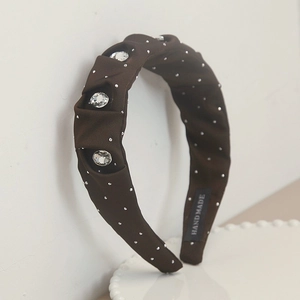 Serre-tête en satin plissé marron avec strass et perles sur plateau blanc