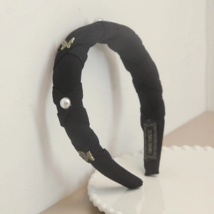 Knotted black headband featuring white pearls and golden rhinestone butterfly accents