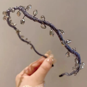 Close-up of beaded headband with grey-purple faceted crystals on a thin metal band