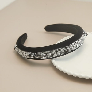 Detail of black velvet padded headband with sparkling crystal rhinestone clusters on a tray