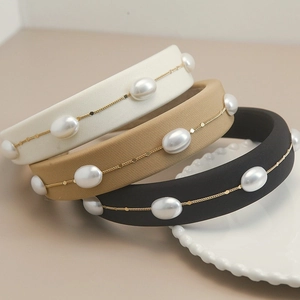 Detail of sponge padded headbands featuring delicate golden chains and white faux pearls