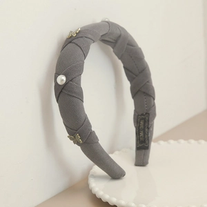 Detail of gray woven headband featuring faux pearls, golden butterfly and Hand Made label